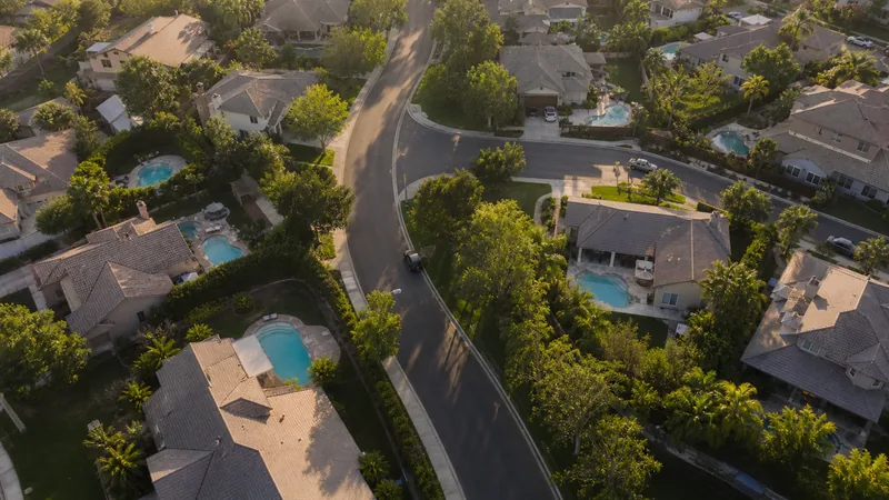 Aerial view of a suburban neighborhood with several backyard pools